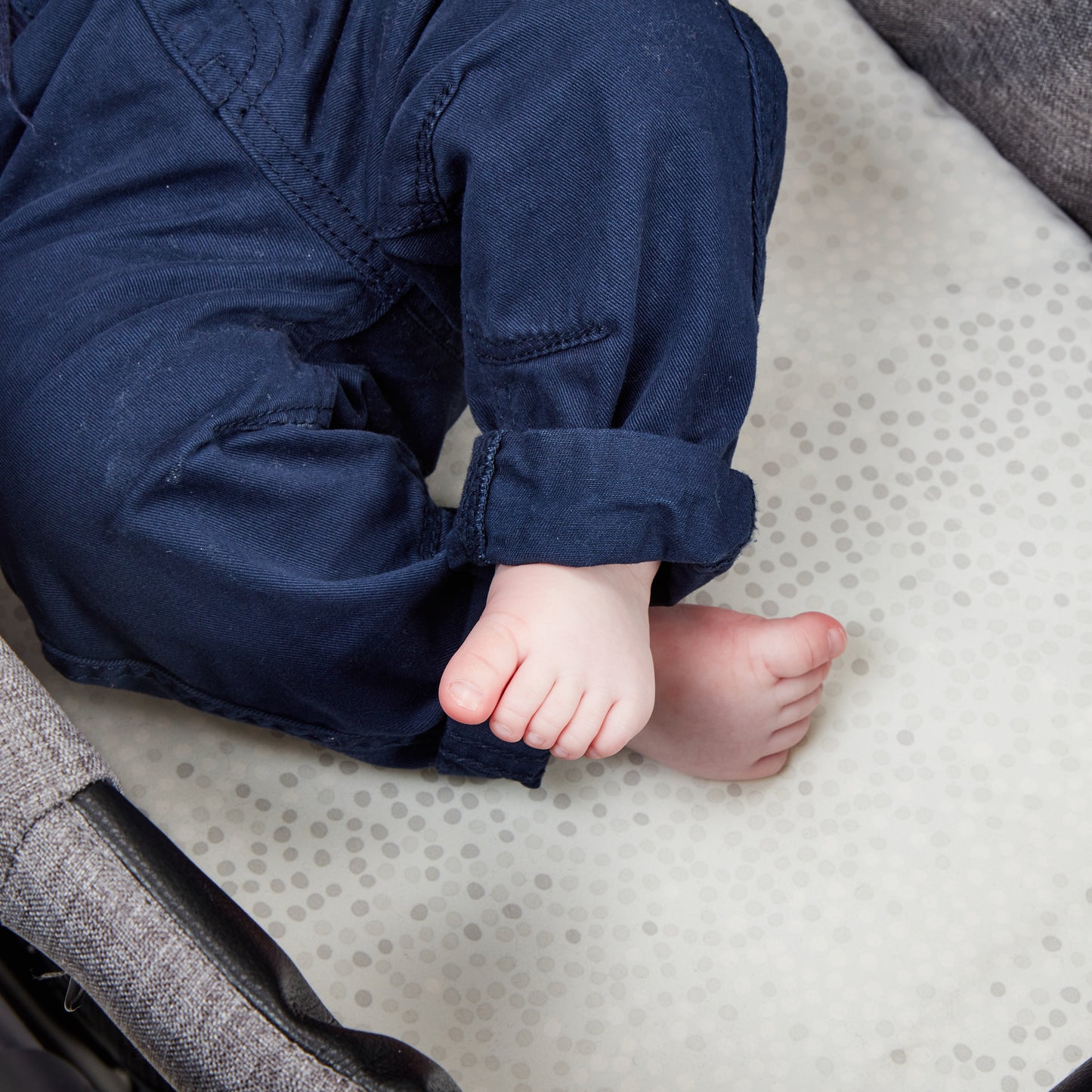 Close-up of baby’s feet resting on pram mattress