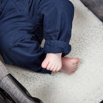 Close-up of baby’s feet resting on pram mattress