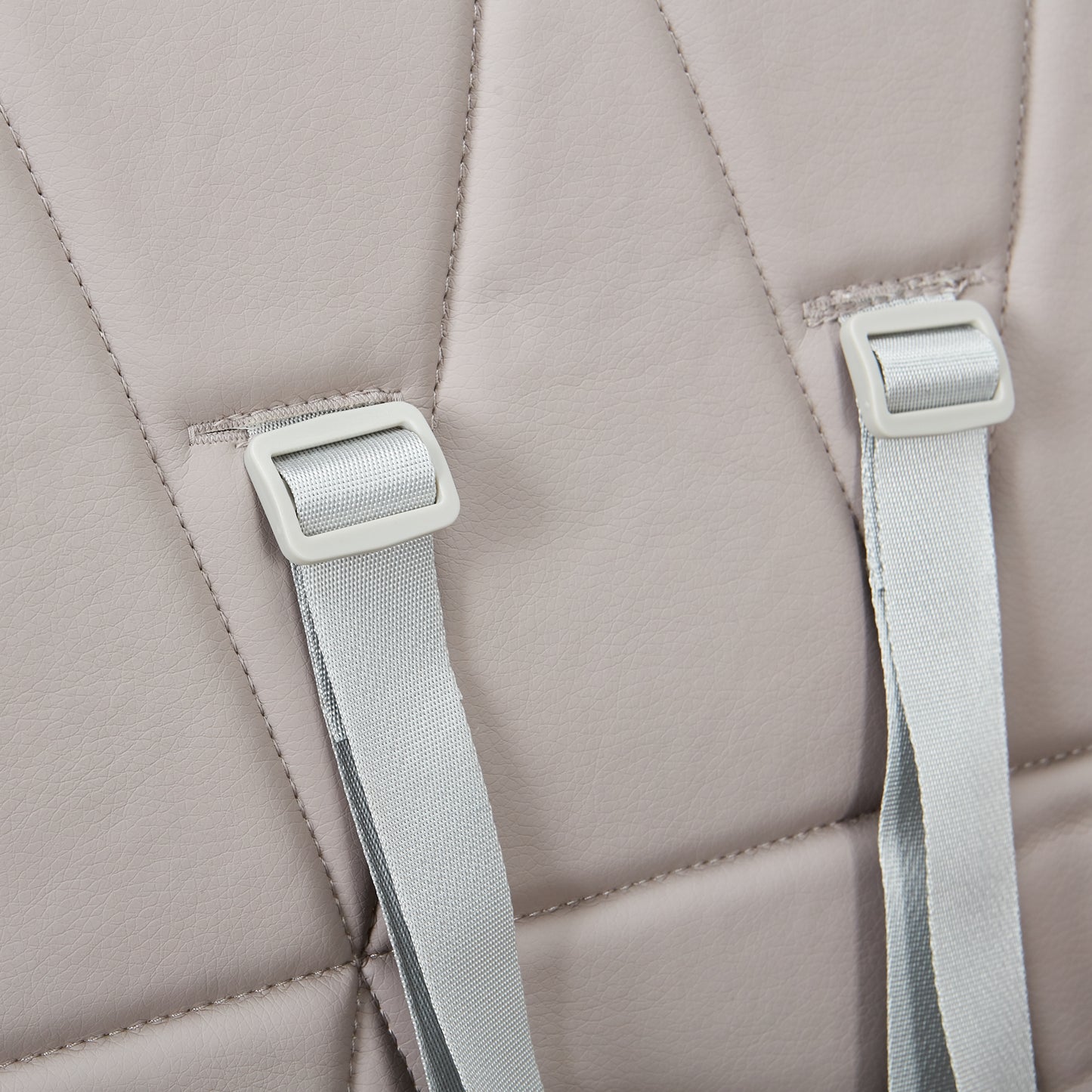 Close-up of a beige backpack with straps and buckles on a matching background