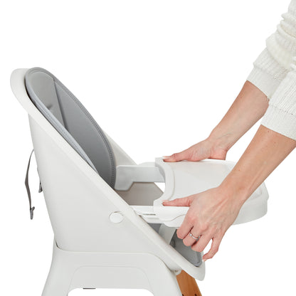 Person adjusting a baby high chair with a white background