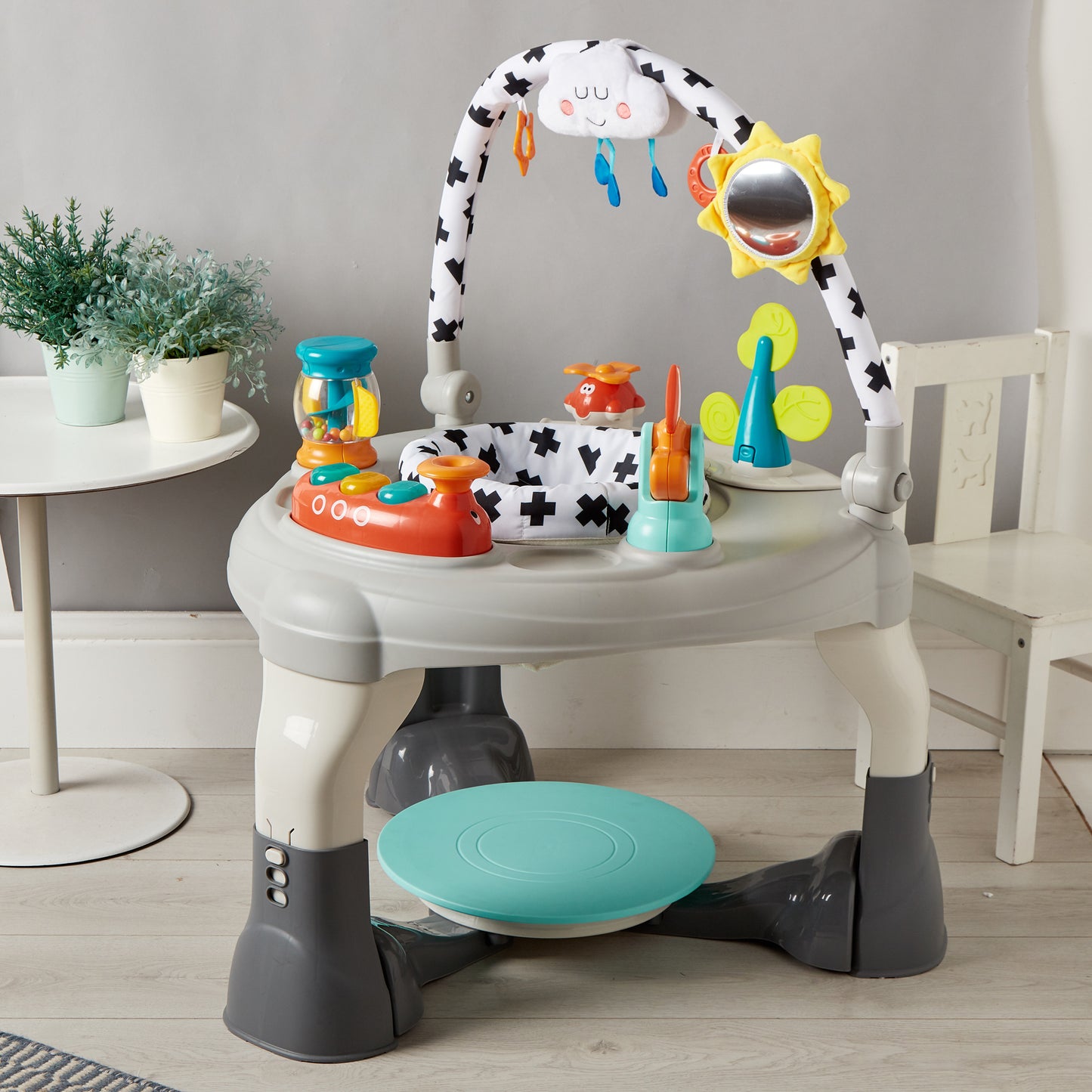 Children's activity center with toys and a stool on a wooden floor.