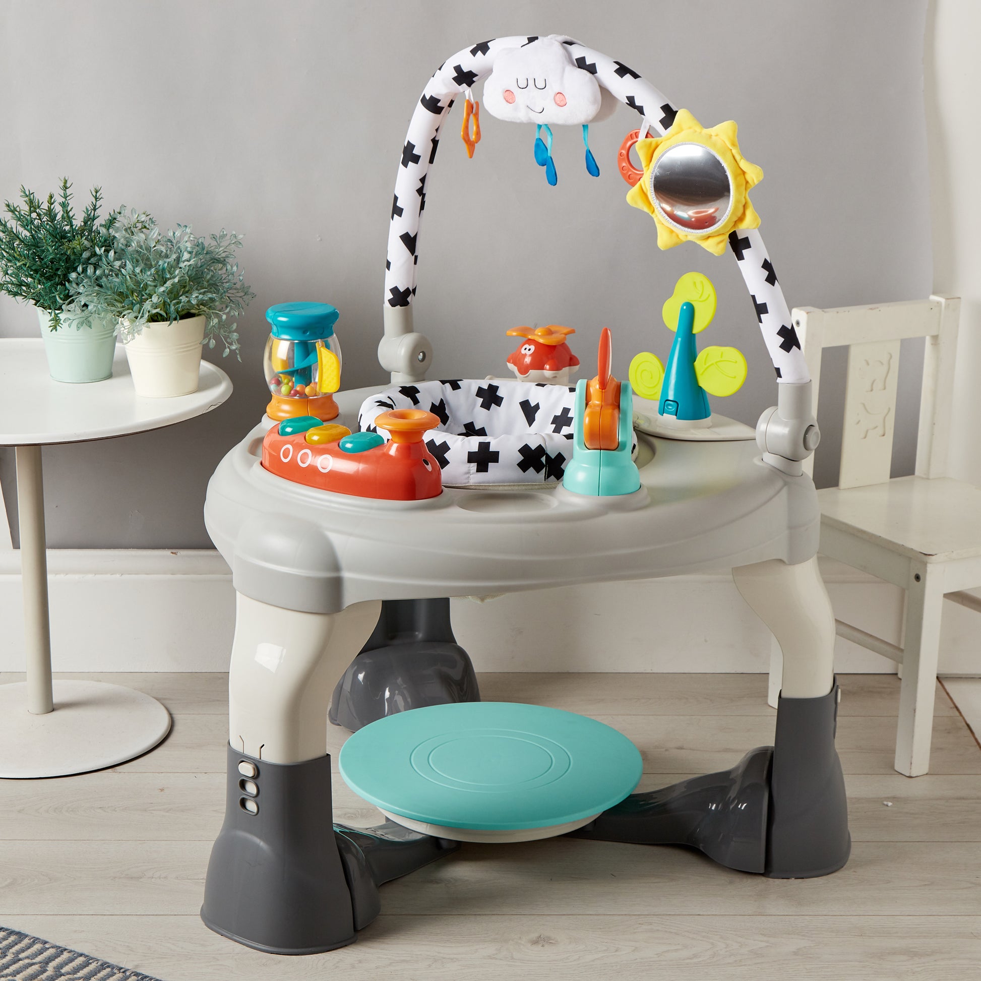 Children's activity center with toys and a stool on a wooden floor.