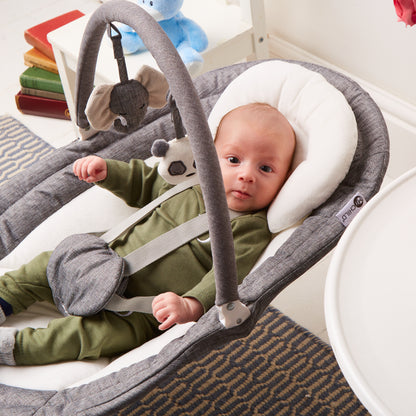 Baby in rocker with toy bar attached, padded seat support