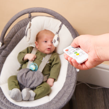 Close-up of baby in rocker with remote control for swing and music