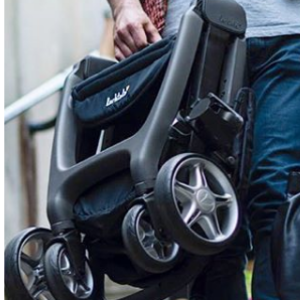 Person holding a black stroller with visible branding.