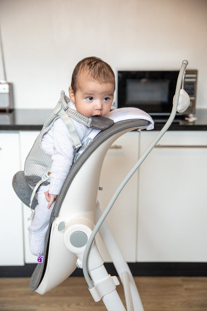 Baby sitting in BabyUp® colic & reflux support seat, side view